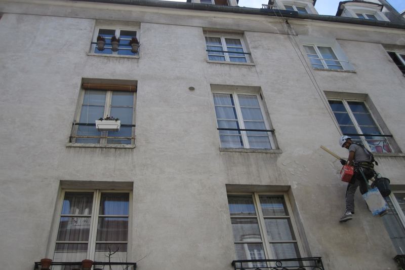 Painter working on a building facade